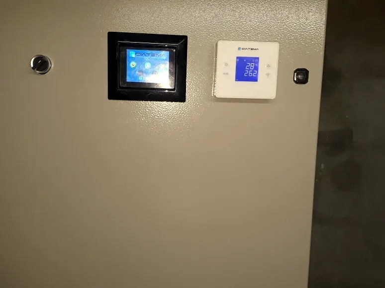 Panel táctil y termostato instalados sobre una pared
