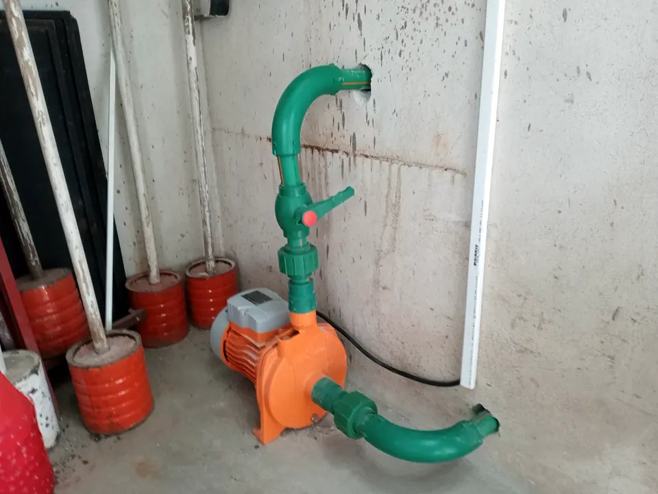 Bomba de agua con cañerías verdes en un cuarto técnico