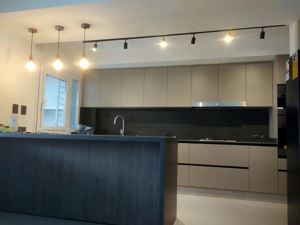 Cocina con luces colgantes y riel de spots sobre la mesada