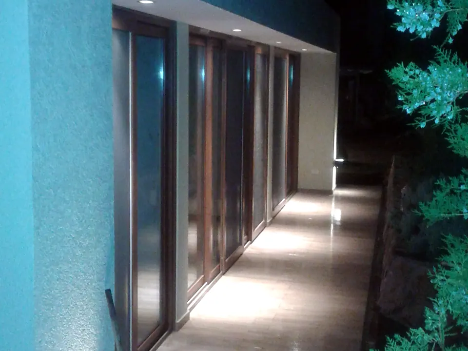 Galería exterior iluminada de noche con balizas empotradas