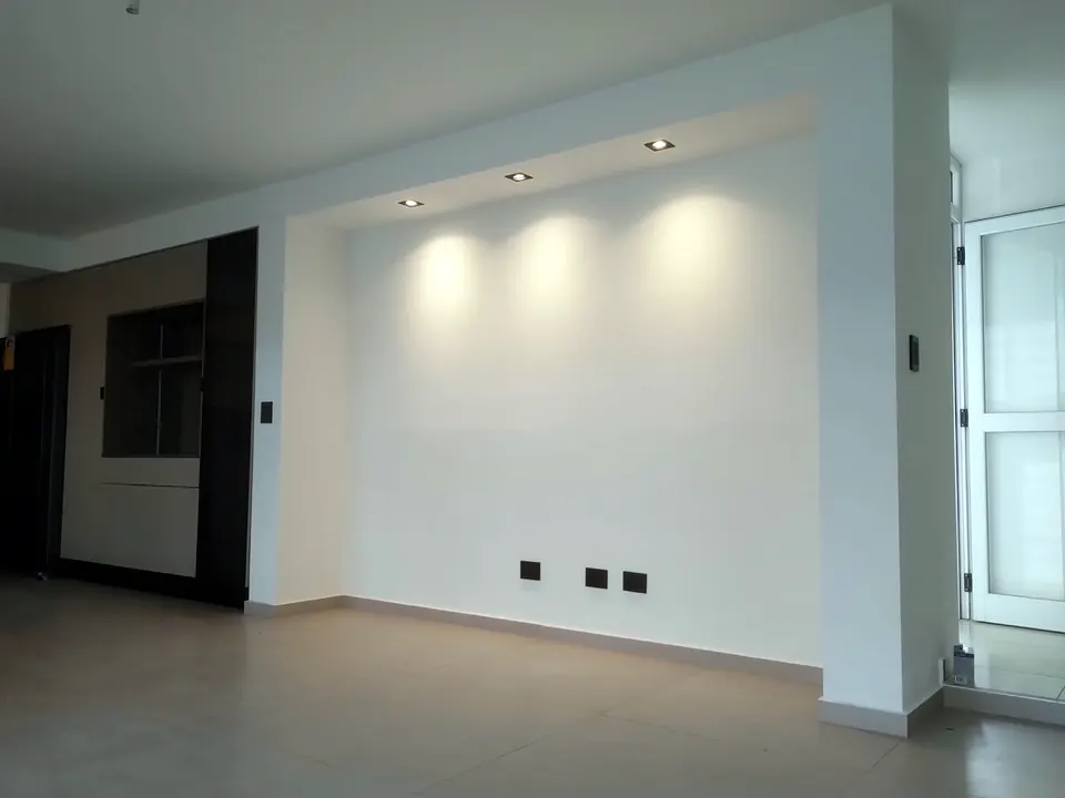 Pared de living con spots empotrados encendidos en una vivienda terminada